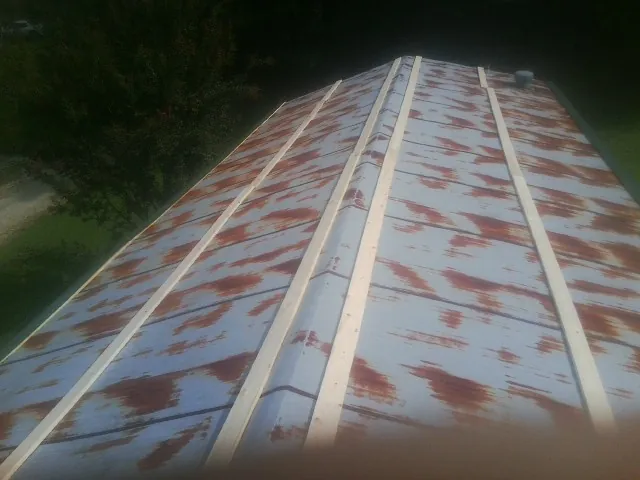 Rusted metal roof panels with new wood purlins before replacement — Storm Damage Roof Repair in Lewis by Roofing Brothers
