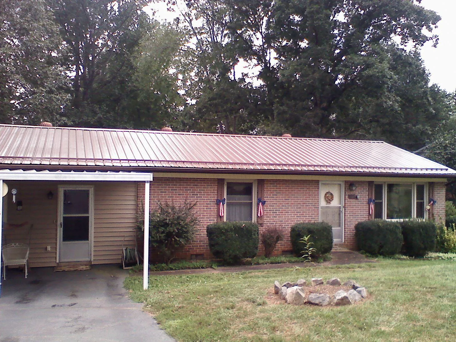 Bronze metal roof and carport on a brick ranch home — Roof Repair work by our crew in Lewis